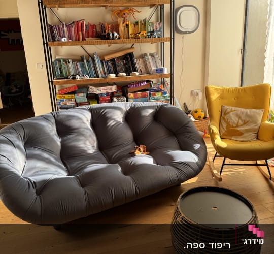 כרית צהובה על כורסה, ספה מרופדת אפורה